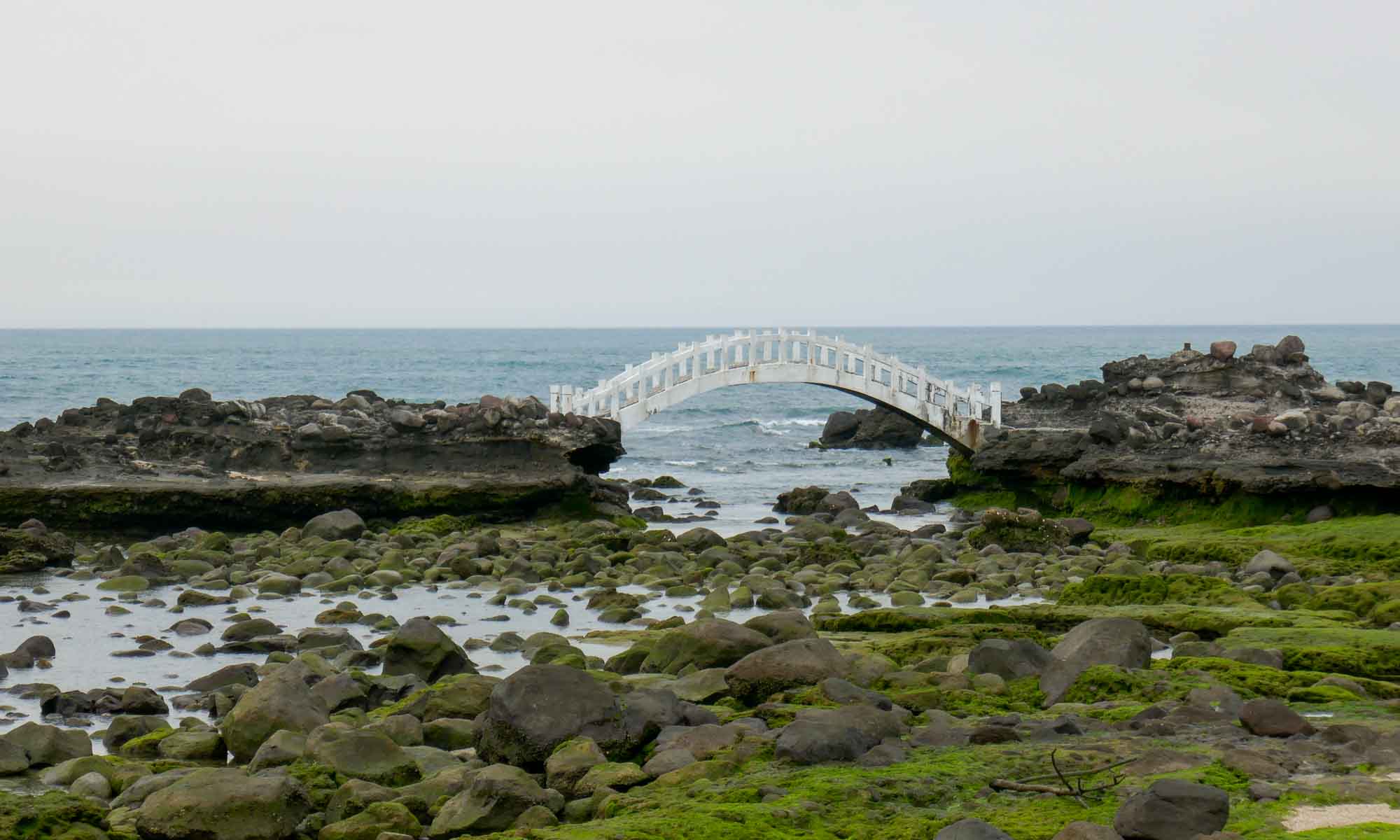 Small bridge in the sea behind the arch