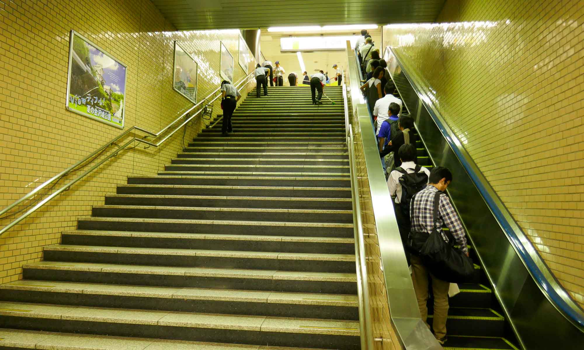 Cleaners cleaning the stairs and banisters in the Tokyo metro